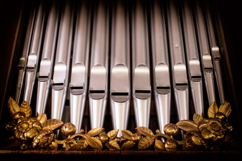 a close up of a pipe organ with gold flowers